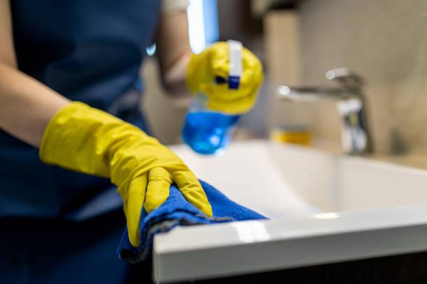 istock Cleaning a bathroom sink with blue liquid and cloth while wearing yellow gloves during daytime 2215962905