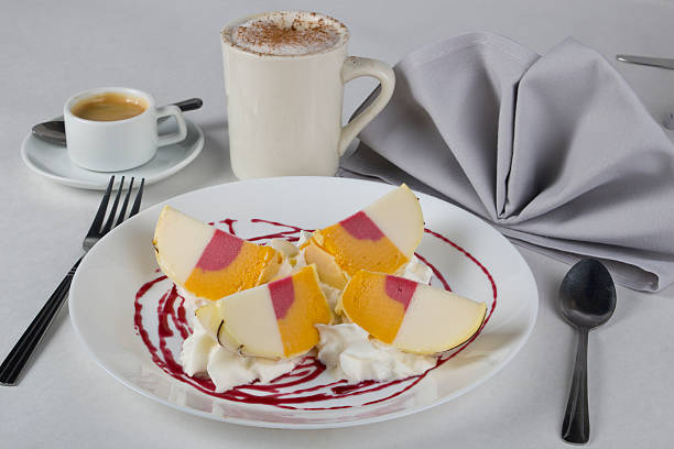 Tartufo vanilla gelato and mango sorbet on a plate in an Italian restaurant, with a cup of cappuccino.