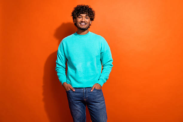 istock Photo of cheerful confident young man put hands pockets posing empty space isolated on orange color background 2215969799