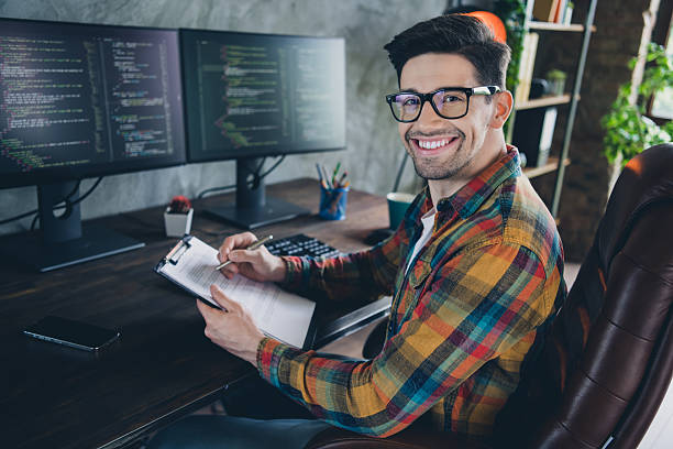 istock Portrait of smart positive front end developer guy sitting chair hold pen write clipboard pc display business center indoors 2215971061