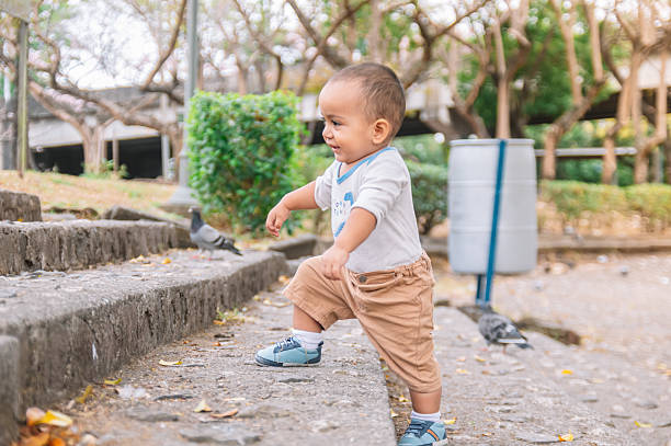 Baby climbing stairs in the park, latin american baby climbs his first steps without help