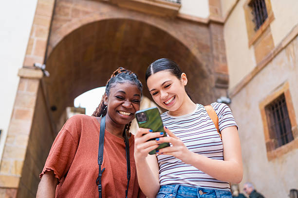 istock Young adults smiling, sharing digital moment, displaying smartphone connection and social interaction through modern technology 2215972346