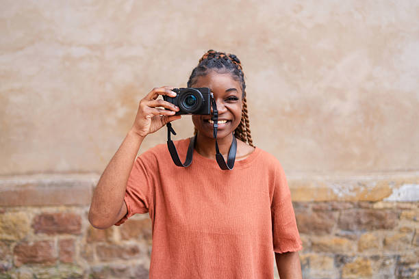 istock Young photographer smiling while capturing vibrant moments with a digital camera, enjoying the outdoors and embracing the joy of creativity 2215972355