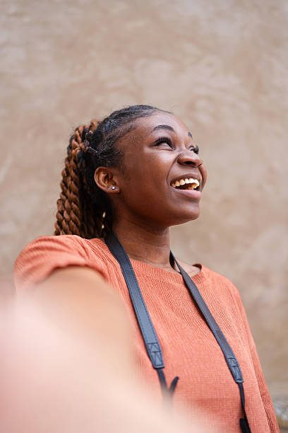 istock Young female photographer smiling while taking a selfie with her camera, radiating joy and enthusiasm as she connects with the viewer 2215972362