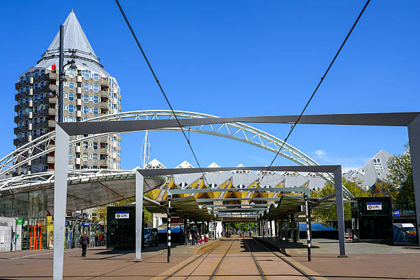 Tram station under blue sky, with the cube houses in the background