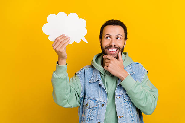 istock Photo of attractive hispanic young guy hold bubble cloud touch chin look decide eureka brainstorming isolated on yellow color background 2215973399