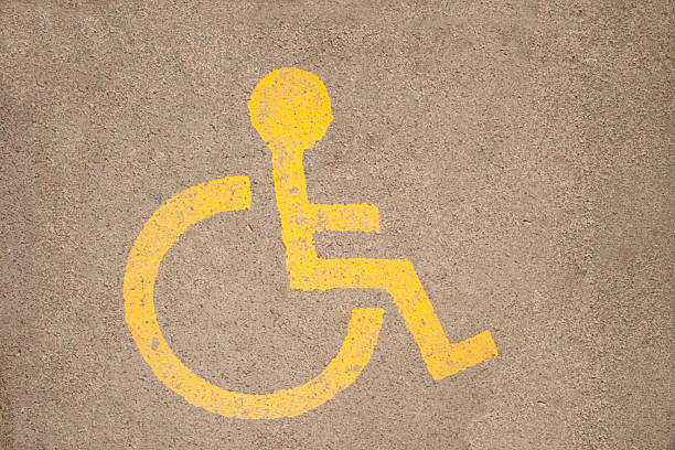 Close-up taken of disabled chair symbol drawn on the asphalt with yellow paint.Not an illustration