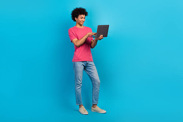 istock Full size photo of handsome young male hold netbook working coder manager dressed stylish pink outfit isolated on blue color background 2215976672