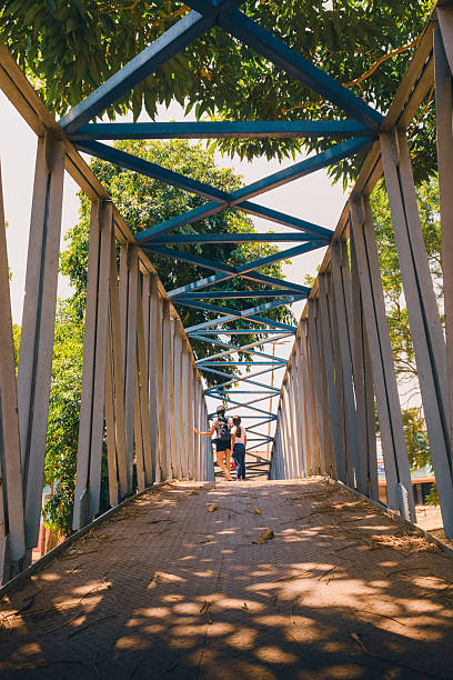 People walking on a pedestrian bridge on a sunny day