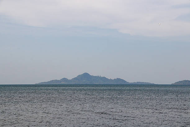 istock Distant mountains over calm water under soft cloudy skies. 2215981647