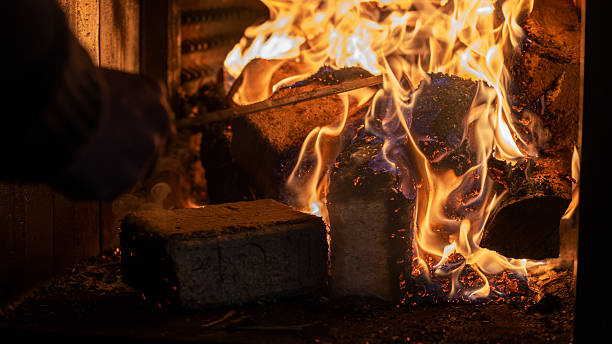 Eco-friendly compressed wood briquettes ignite a warm, inviting fire in a modern stove, showcasing sustainable heating and cozy ambiance for any home