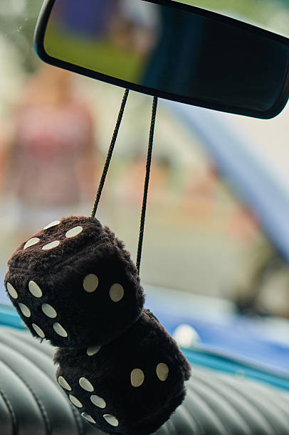istock Black Fuzzy Dice hanging from the rear view mirror 2215991630