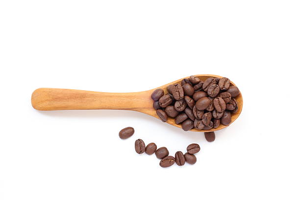 istock Top view of brown roasted coffee beans in spoon on white background 2215992949