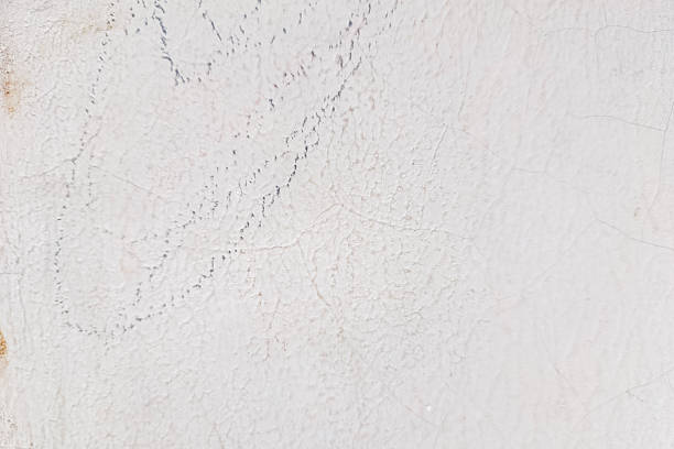 istock A textured white wall with visible cracks and faint, scattered dark marks. 2216000602