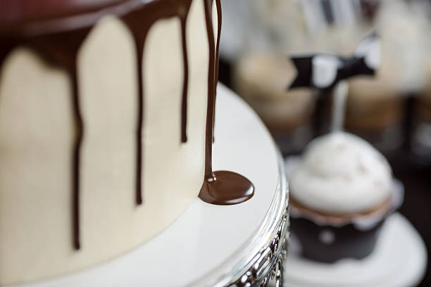 Close-up shot of an elegant white cake with rich chocolate dripping down the sides. Perfect for wedding, birthday, or special event promotions. High-quality image showcasing gourmet dessert details.