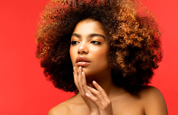 Portrait of Young African model with a beautiful makeup over red background. Portrait of Young African model with a beautiful makeup over red background. Close up. teenage girl before and after make up stock pictures, royalty-free photos & images