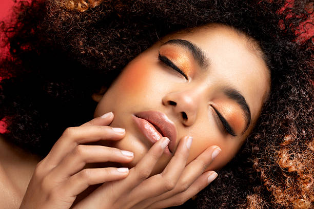 Portrait of Young African model with a beautiful makeup over red background. Portrait of Young African model with a beautiful makeup over red background. Close up. teenage girl before and after make up stock pictures, royalty-free photos & images