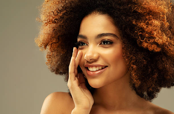 Portrait of sensual young curly african woman against beige background. Beauty and fashion concept. Portrait of sensual young curly african woman against beige background. Beauty, people and fashion concept. teenage girl before and after make up stock pictures, royalty-free photos & images