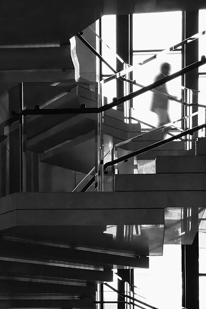 istock Spiral staircase interior building with people walk down stairs Architecture details 2216011835