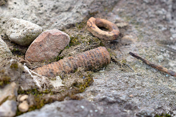 istock Rusty nail and corroded metal debris lying on mossy ground among rocks highlighting potential injury risk and tetanus infection in outdoor abandoned area 2216012355