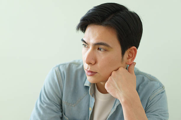 Pensive Young Man Sitting in a Calm and Serene Setting Indoors