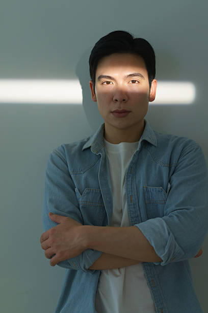 istock Young Individual in Thoughtful Mood with Natural Lighting Effects on Face 2216013943