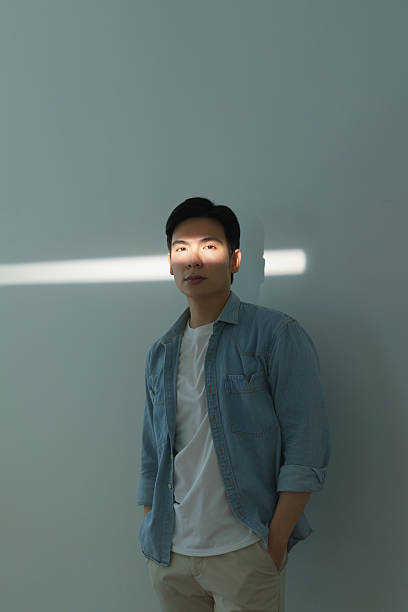 istock Young Man in Casual Denim Shirt in Dramatic Lighting 2216013947