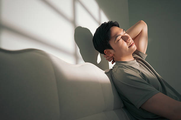 istock Relaxed Man Enjoying Sunlight Indoors with Soft Shadows and Peaceful Atmosphere 2216013979