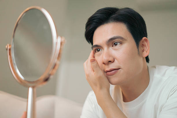 istock Man Looking Thoughtfully at a Mirror in a Calm Home Setting 2216014026