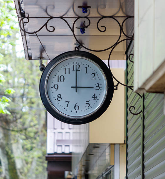 istock A clock hanging on a building with the hands at 3:00 2216014899