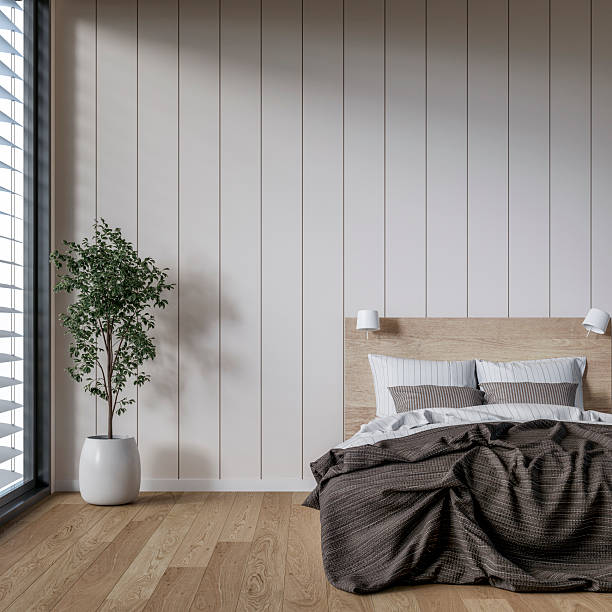 istock A front view of a modern, minimalistic bedroom with a bed, an empty shiplap paneled wall, a potted plant, windows and decoration 2216016065