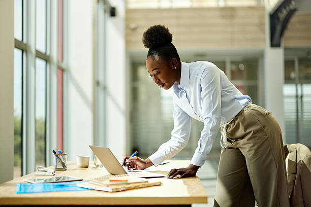 istock Black businesswoman taking notes while working on laptop in the office. 2216016975