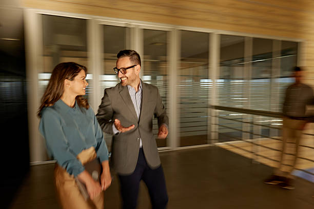 istock Happy business colleagues talking on the move in blurred motion at corridor. 2216017741