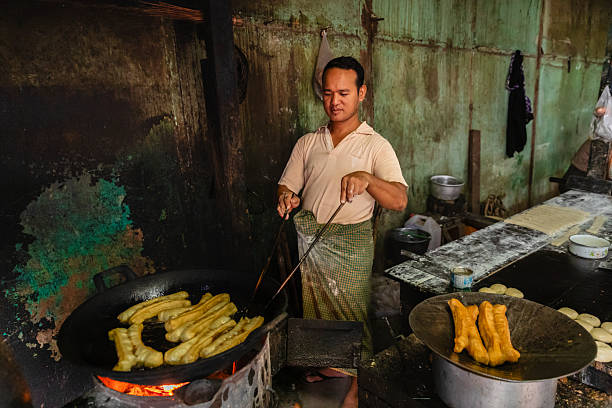 istock Burmese man preparing and selling fresh Chinese doughnuts, Myanmar 2216019821