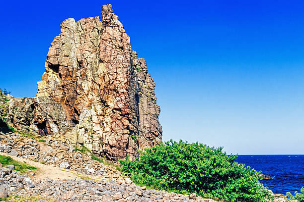 Rear view of man wearing white banyan climbing on the cliff at the time of day during summer season with copy space. 