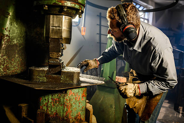 istock Mid Adult Blacksmith Using Hydraulic Press in Industrial Workshop 2216021416