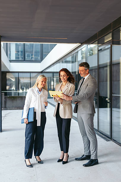 istock Corporate professionals discussing digital documentation during business meeting in contemporary office hallway 2216022770