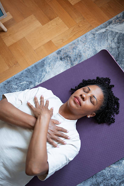 istock Woman relaxed lying on yoga mat practicing mindfulness at home 2216024289