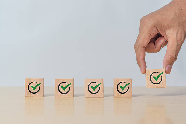 istock Wooden blocks checklist and green check mark icon with hand on table background. Business task sign appointment schedule concept. Businessman placing correct evaluation satisfaction checkbox symbol 2216024732