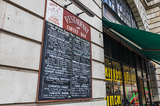 Urban restaurant exterior featuring a detailed menu board and vibrant storefront under a green awning. London, UK, 1 April 2024