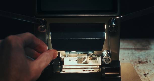 istock A director adjusts 16mm film placement on an analog editing table in a backstage setup. 2216025705