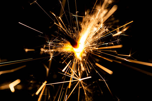 istock Sparkler Firework Spark Igniting in Dark Space with Radiant Light Trails 2216025917