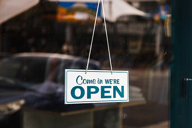 istock Small Open Sign Hanging on Glass Door Inviting Customers into a Cozy Storefront 2216026559