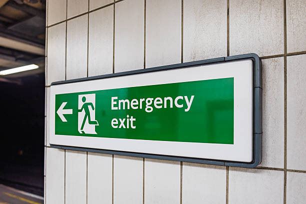 istock Green Emergency Exit Sign in Underground Subway Station with Directional Arrow 2216026823