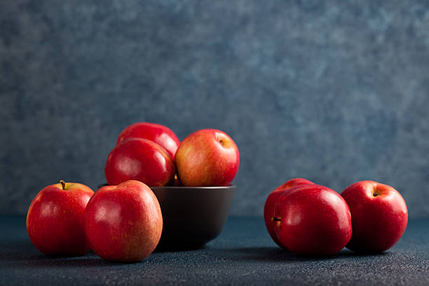 istock Bowl of Red Apples on Blue Background 2216032406