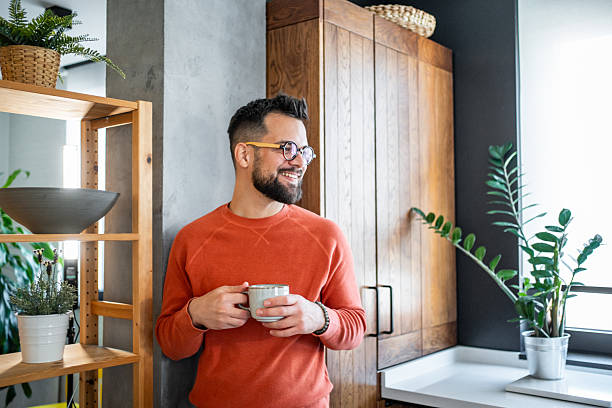 istock Young man enjoying a cup of coffee in his modern apartment kitchen 2216032525