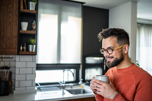 istock Young man enjoying a cup of coffee in his modern kitchen 2216032552