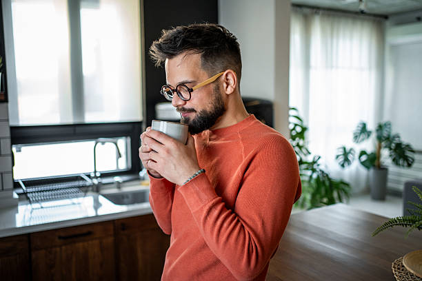 istock Young man enjoying a cup of coffee in his modern kitchen 2216032557