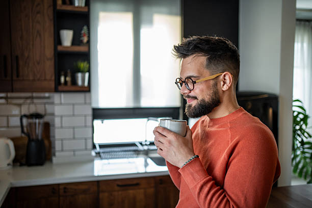 istock Young man enjoying a cup of coffee in his modern kitchen 2216032562