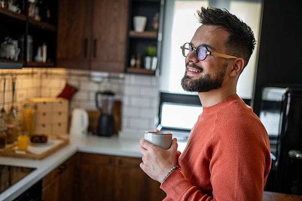 istock Young man drinking coffee in his modern kitchen enjoying breakfast 2216032566